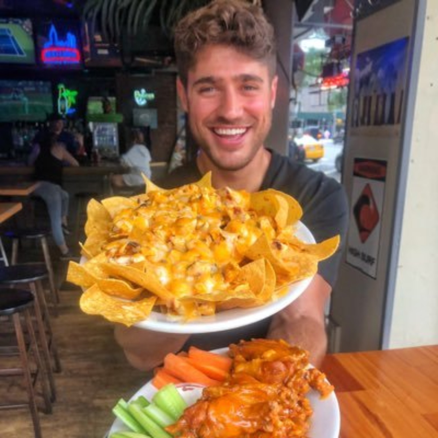 Greg Remmey holding a plate of loaded nachos